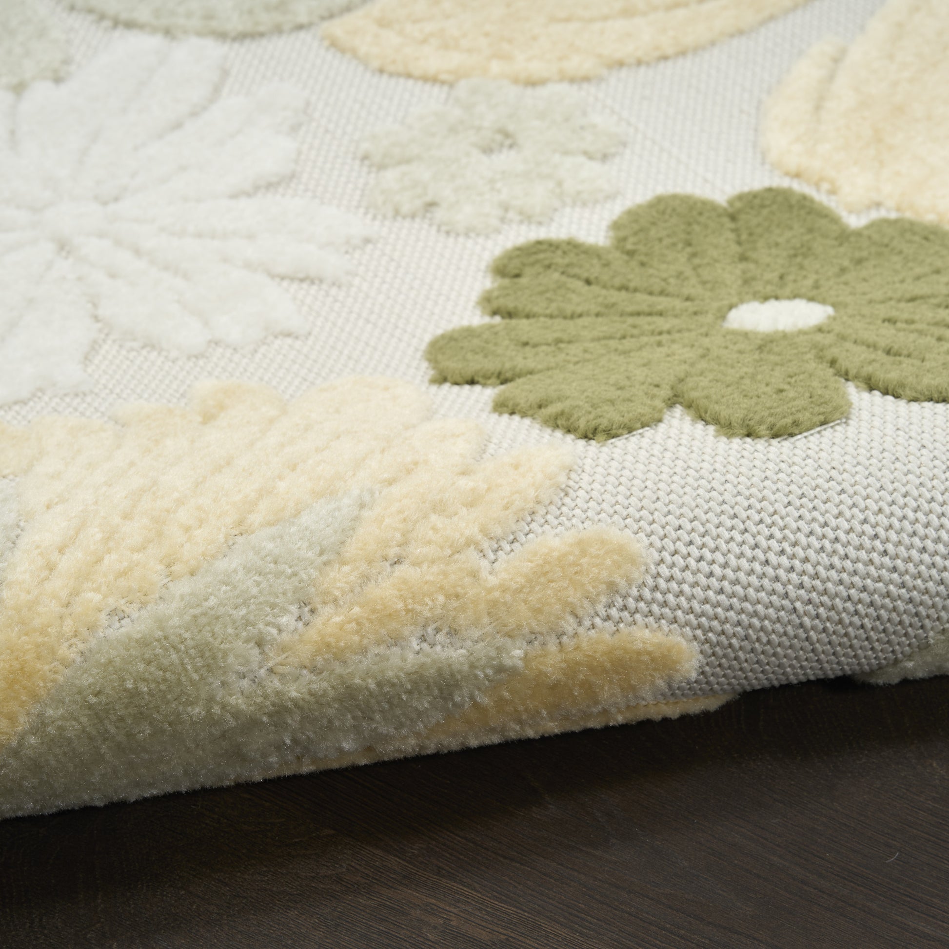 Soft plush rug with cream, pale yellow, & sage green floral motifs on a light gray base; textured pile.