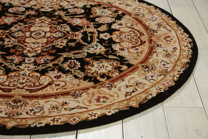 Round oriental-style area rug with black center and cream-and-red floral border on light tiled floor.