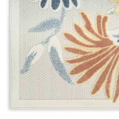 Cream outdoor rug featuring large orange-brown petals and blue leaves with a pale border.