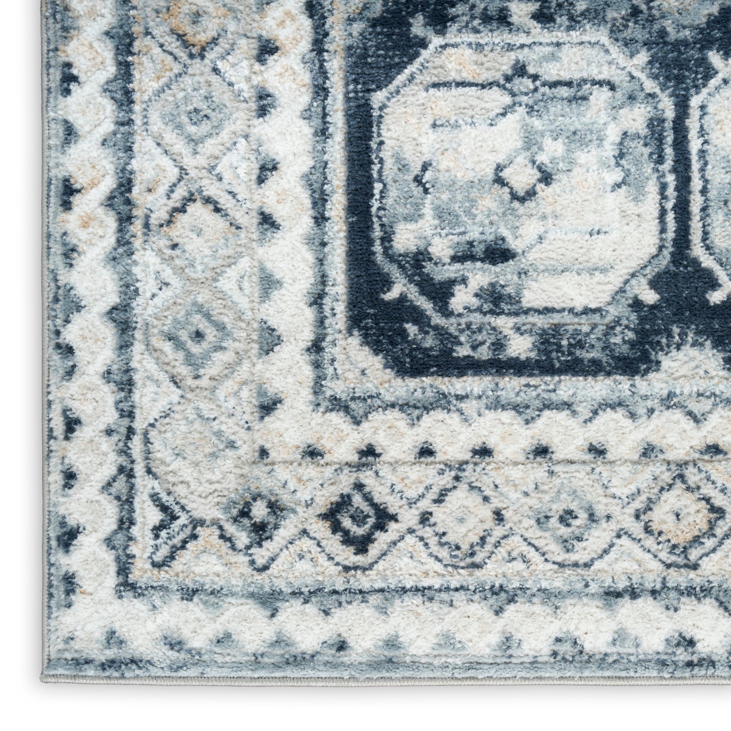 Navy, light blue and ivory geometric area rug with a bordered central medallion pattern.