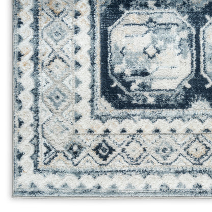 Navy, light blue and ivory geometric area rug with a bordered central medallion pattern.