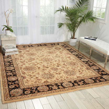 Rectangular beige oriental area rug with cream, brown & red medallions and a black floral border, in a bright living room.