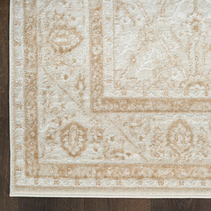 Cream and beige patterned area rug with floral border, plush pile, on dark wood floor.