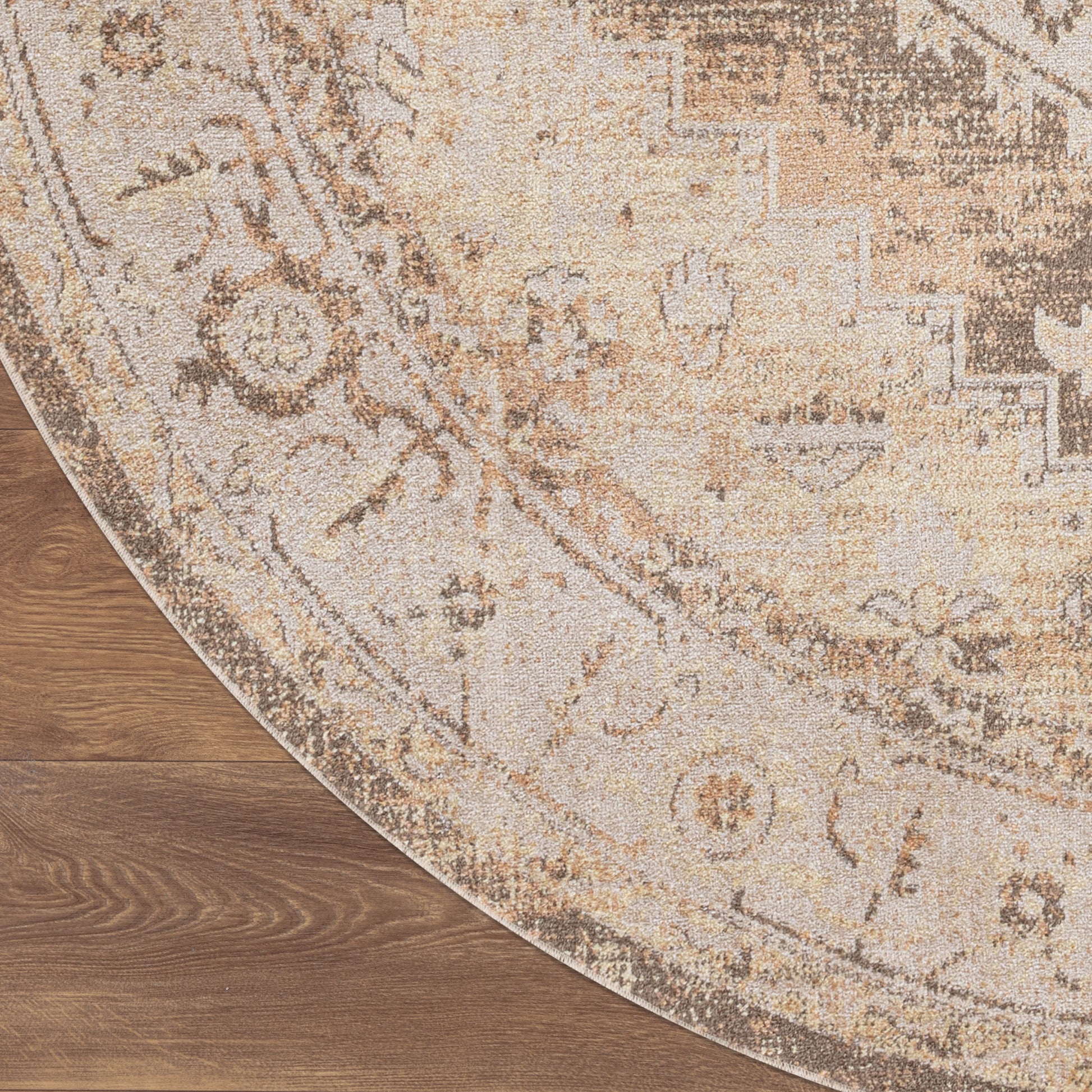 Round beige rug with vintage floral pattern in cream and tan on wooden floor.