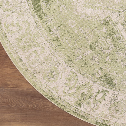Round green & ivory patterned rug with ornate floral motif on hardwood floor.