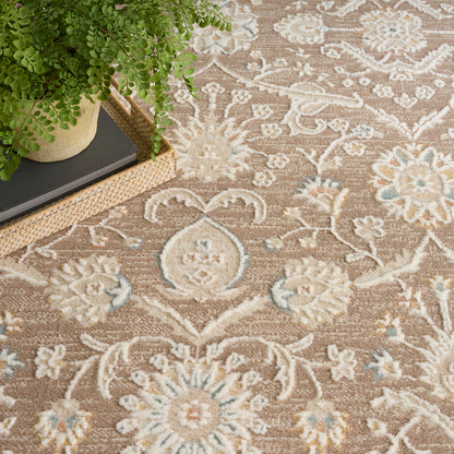 Beige floral rug with cream and pale blue motifs; green potted plant on a woven tray beside.