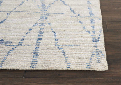Cream rug with blue abstract geometric lines on dark wood floor; soft, low-pile textile.