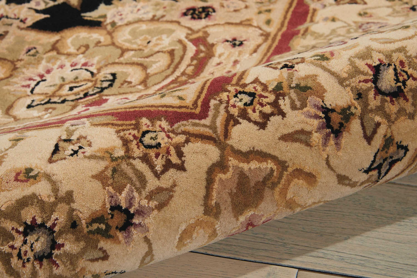 Beige Persian-style area rug with floral motifs in cream, brown, red and green; plush pile on wooden floor.