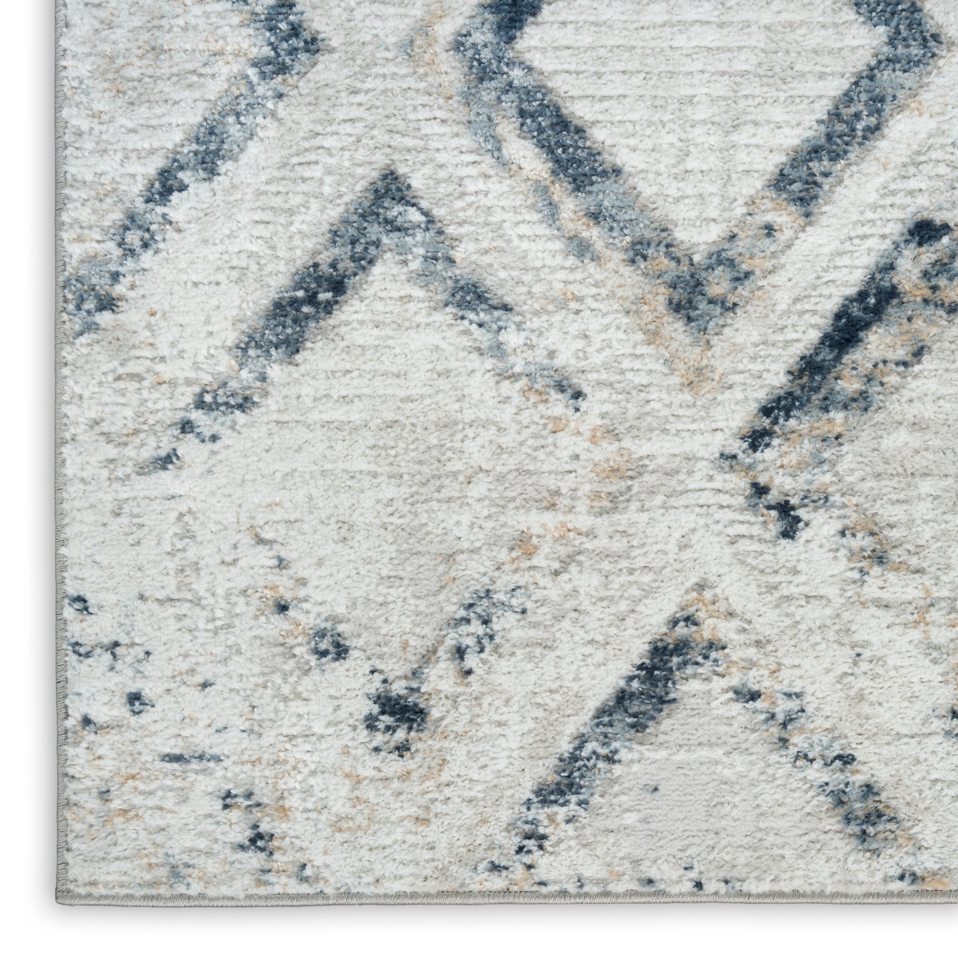 Cream rug with blue-gray geometric diamonds and chevrons; soft textured pile, modern cozy decor.