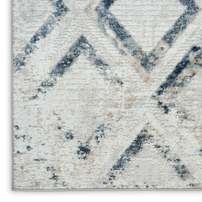 Cream rug with blue-gray geometric diamonds and chevrons; soft textured pile, modern cozy decor.