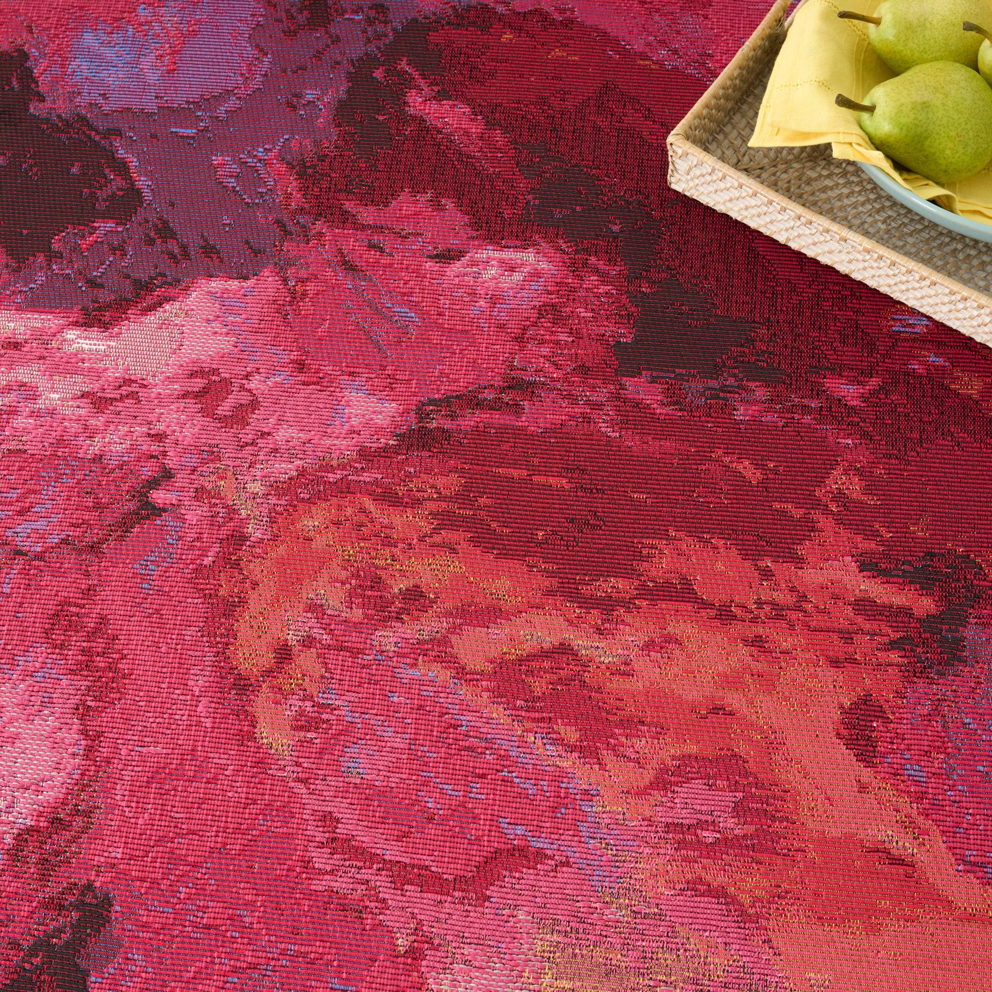 Red abstract floral rug with pink and orange hues.