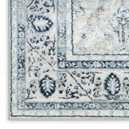 Blue and ivory oriental area rug close-up, intricate floral border and central medallion motif.