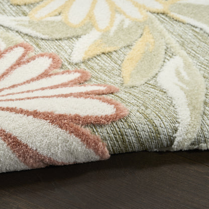 Pastel floral area rug with pink, cream and yellow petals on a green woven base; shaggy pile and folded edge on dark wood.