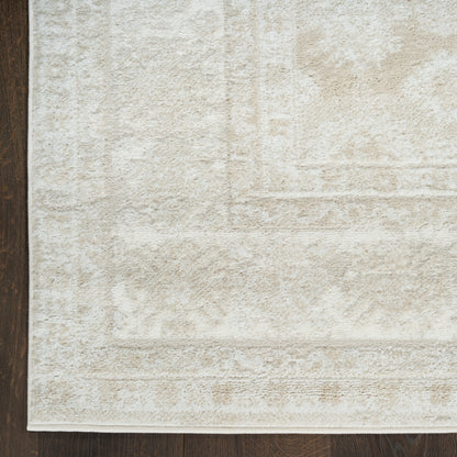 Cream-colored rectangular rug with subtle textured pattern and light border on dark hardwood floor.