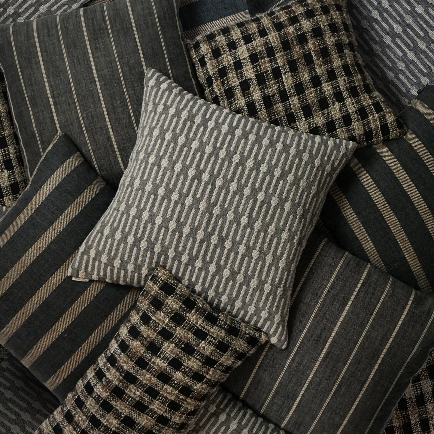 24" x 24" decorative pillow with striped, checkered & geometric patterns in charcoal, taupe & beige.