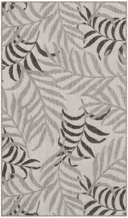 Rectangular woven rug with neutral gray palm/fern leaf pattern, soft textured surface, modern botanical style.