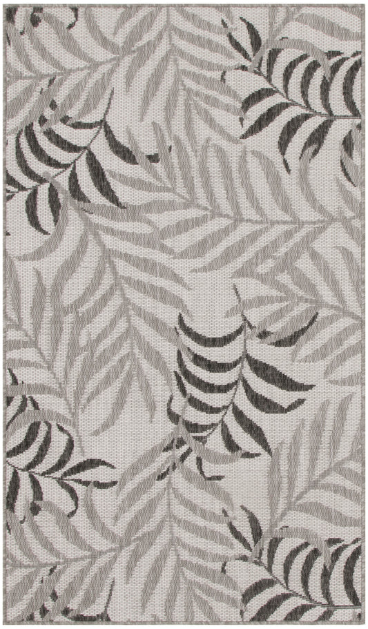 Rectangular woven rug with neutral gray palm/fern leaf pattern, soft textured surface, modern botanical style.