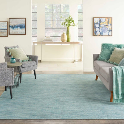 8x10 aqua blue indoor outdoor area rug from the Positano collection by Nourison featuring a modern solid design with subtle woven texture. Durable polypropylene machine-made rug designed for patios, decks, porches, living rooms, bedrooms, and dining rooms. Lightweight, stain-resistant, and easy-clean rug ideal for high-traffic areas and homes with pets or kids. Modern coastal rug perfect for contemporary, minimalist, and boho home decor.
