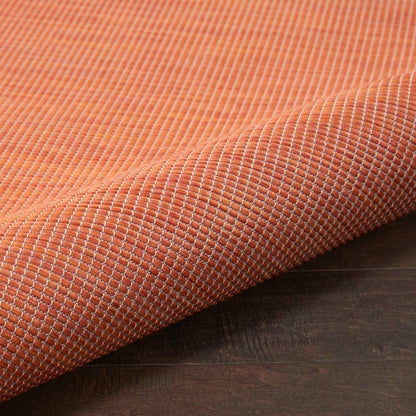 Nourison Positano 8x10 terracotta indoor outdoor area rug, modern flatweave polypropylene rug in warm Orange/terracotta color, durable low pile patio rug for deck balcony living room dining room, contemporary textured solid color rug for boho Mediterranean coastal and modern home decor.