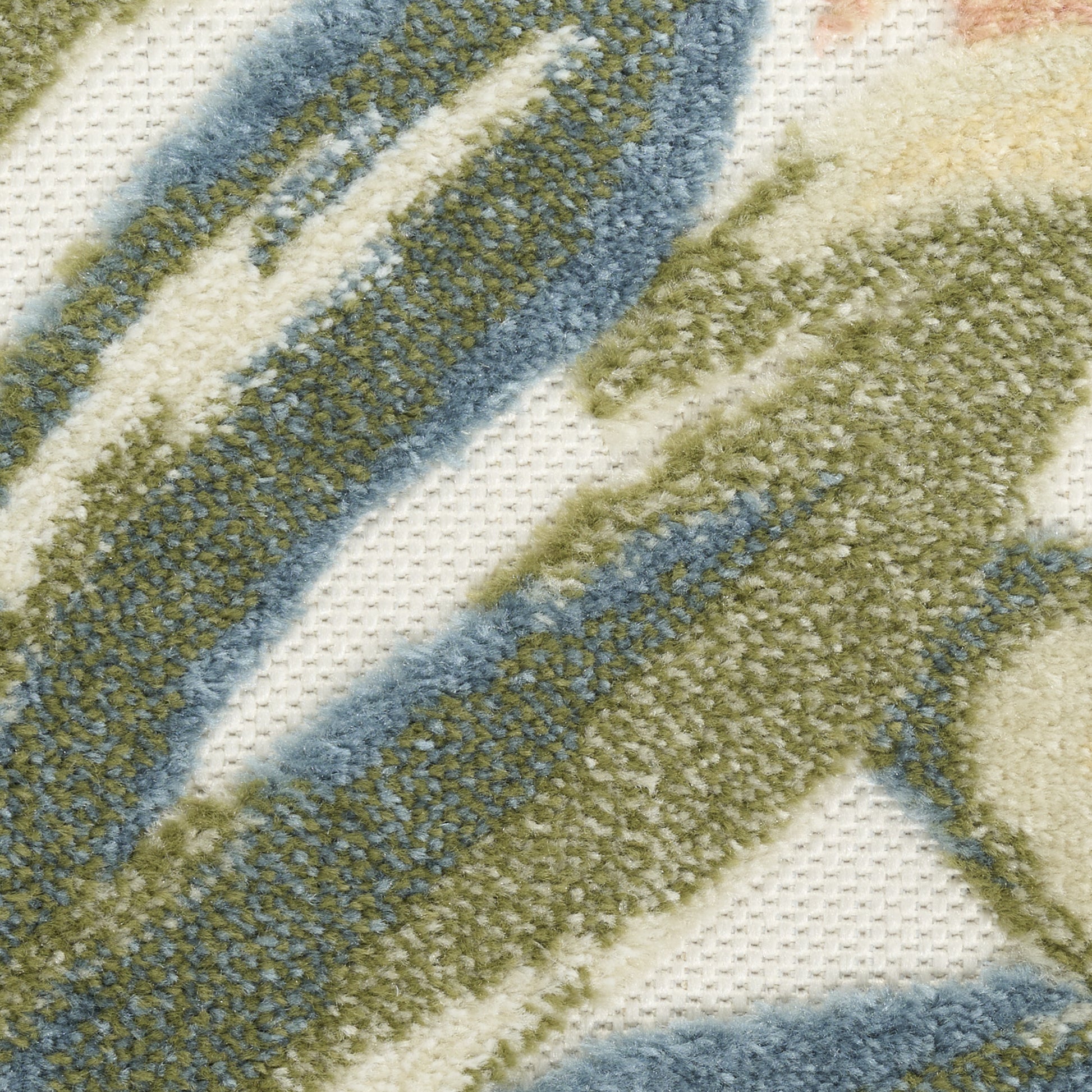 Close-up of a plush rug with cream base and olive green and blue diagonal stripes.