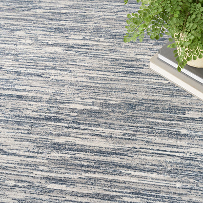 Blue and white striped textured rug with a corner plant and stacked books.