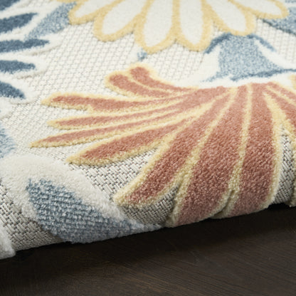 Close-up of an outdoor rug with large blue, yellow & peach floral motifs on a light background, 3' x 4'.