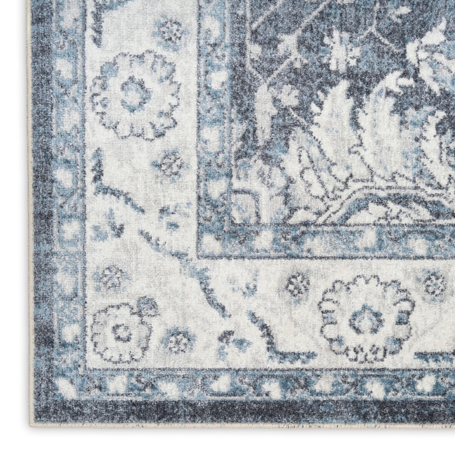 Blue and ivory Persian-style rug close-up showing floral border and corner motif.