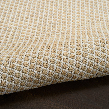 Beige and cream textured woven rug with looped pattern, edge curling on dark wood floor.