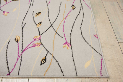Beige-gray area rug with black curved lines and magenta stems, yellow leaves; modern floral pattern on wood floor.