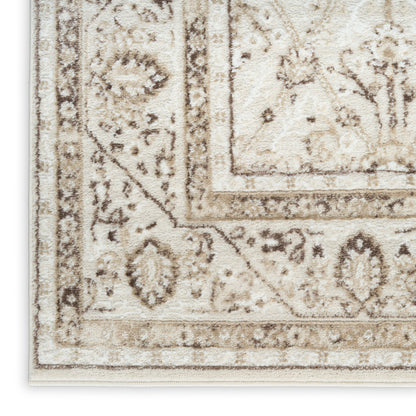 Cream area rug with beige-brown ornate border and floral motif; soft, plush textured pile.