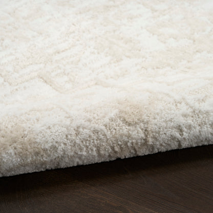 Cream-white shag rug with thick plush pile on dark wood floor, rectangular area rug.