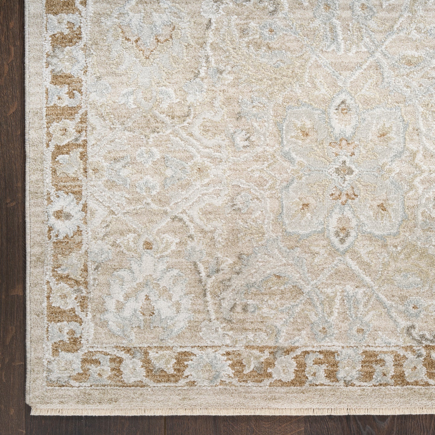 Beige-cream area rug with light blue damask floral pattern and decorative border, fringed edges.