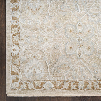 Beige-cream area rug with light blue damask floral pattern and decorative border, fringed edges.