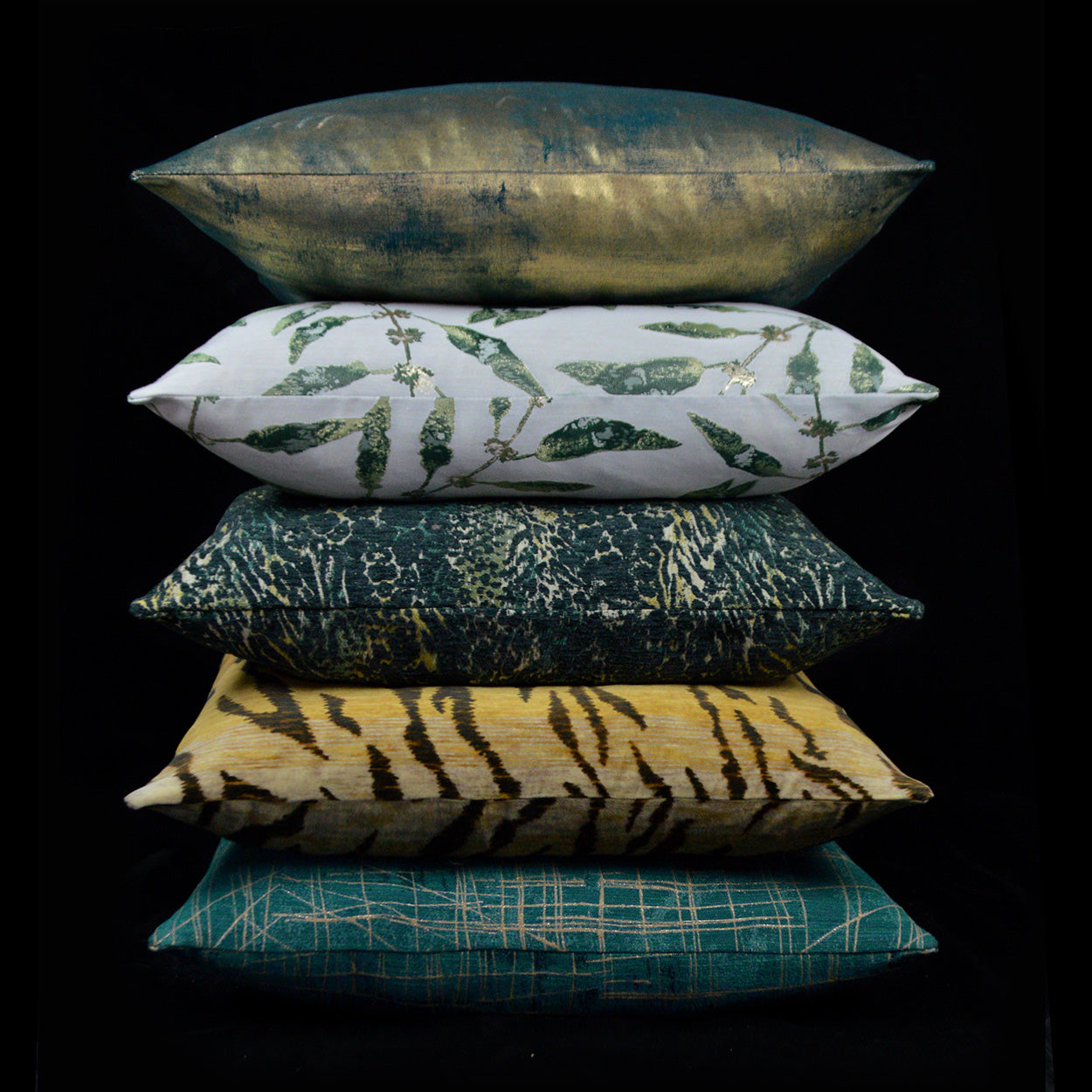 Stack of six rainforest-inspired decorative throw pillows: metallic teal, botanical leaf, tiger stripe, teal plaid.