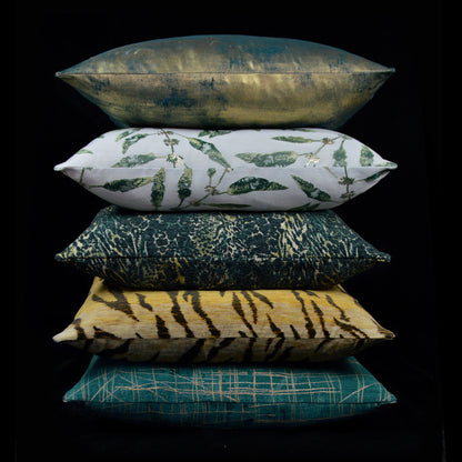 Stack of six rainforest-inspired decorative throw pillows: metallic teal, botanical leaf, tiger stripe, teal plaid.