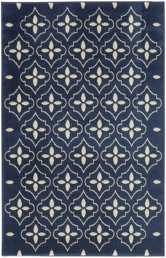 Navy area rug with cream geometric quattrofoil motifs; repeating pattern, soft textured flat-weave, modern traditional style.