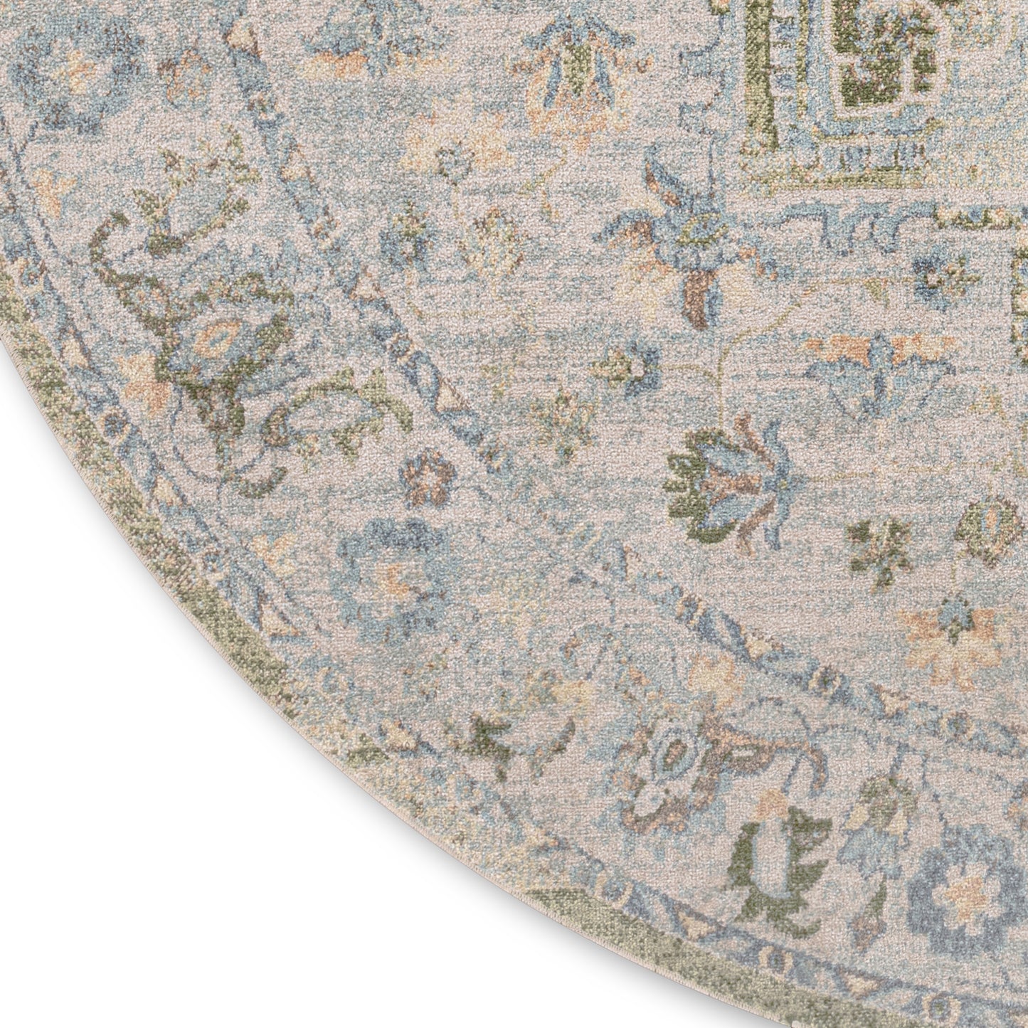 Circular vintage-style rug with soft blue background and beige/sage floral pattern, curved edge visible.