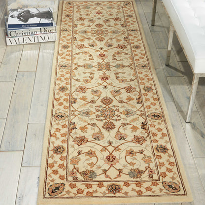 Cream Oriental rug runner with ornate floral vine motif in red, green and brown; tan border.
