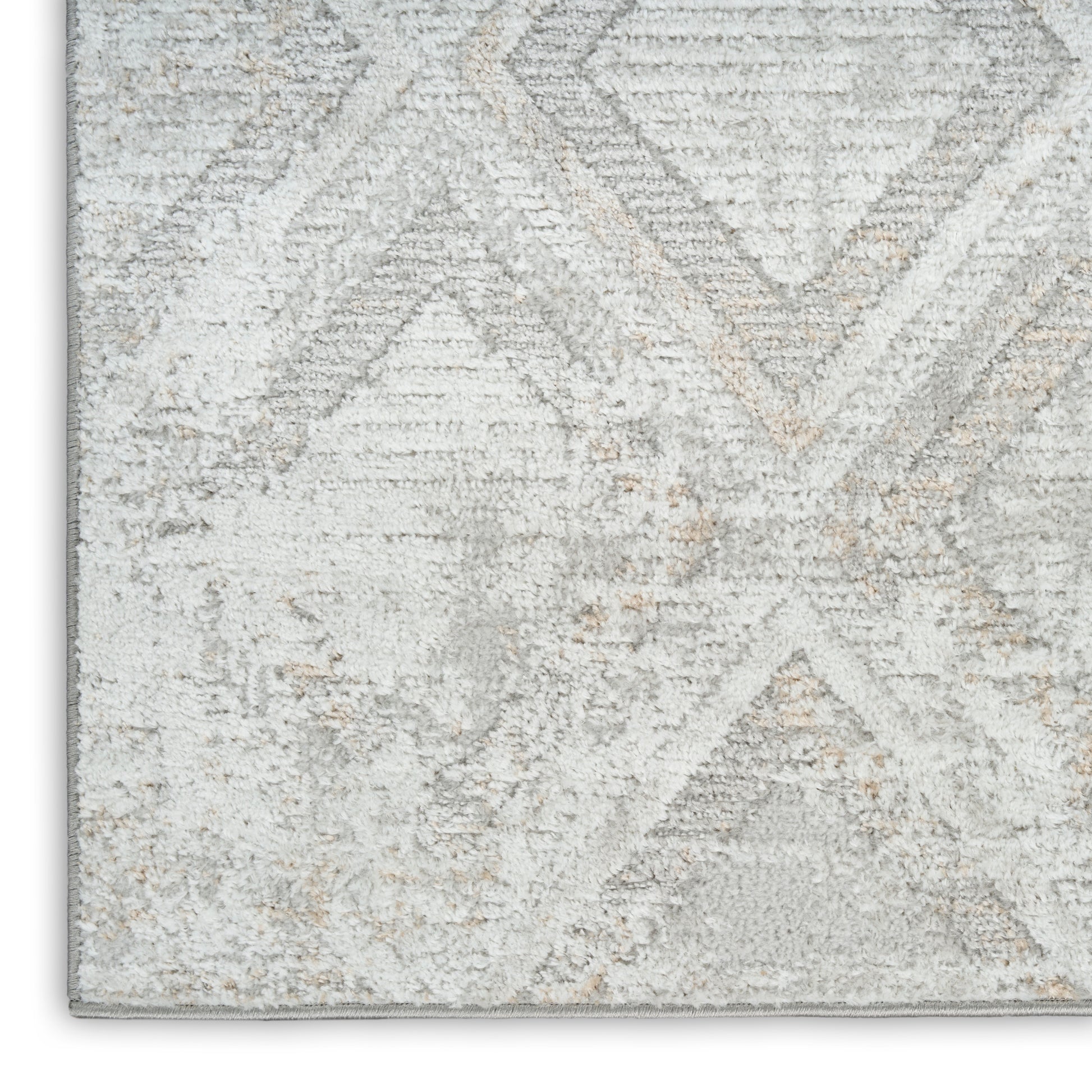 Light gray and ivory geometric patterned rug with distressed texture and plush pile.