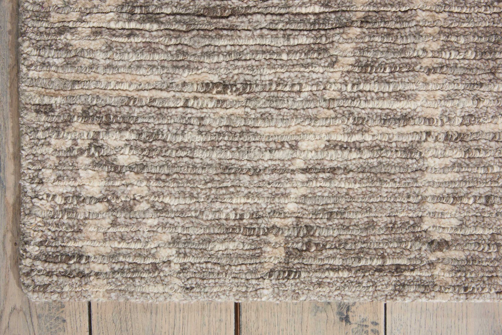 Beige shaggy area rug with soft plush pile in taupe and cream tones (6' x 8') on wooden floor.