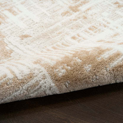 Beige and white shag rug with subtle geometric pattern on dark wood floor.