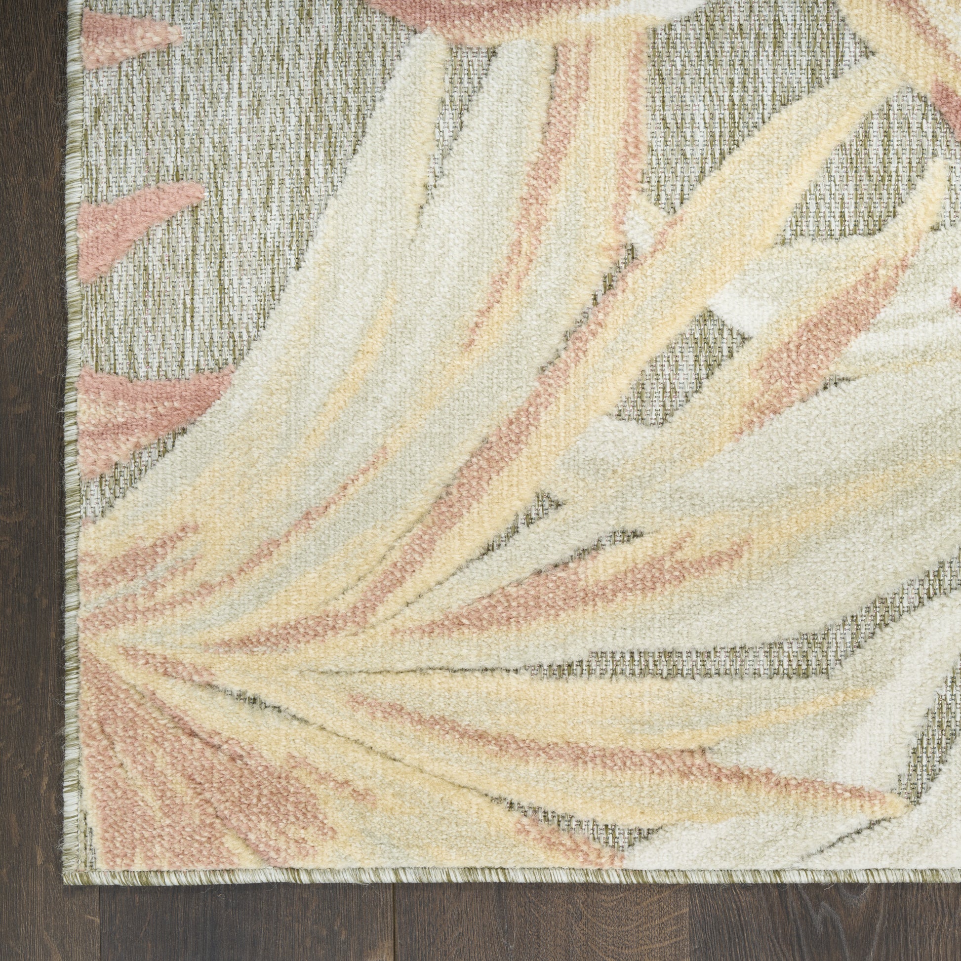 Pastel abstract palm-leaf rug in cream, peach, and pale yellow on a gray background; plush textured pile.