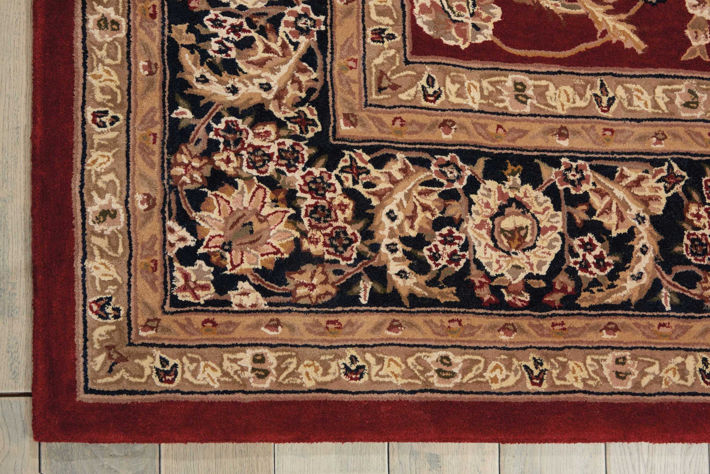Traditional woven oriental rug with floral medallions, navy field, and beige, gold, and red bordered edges.