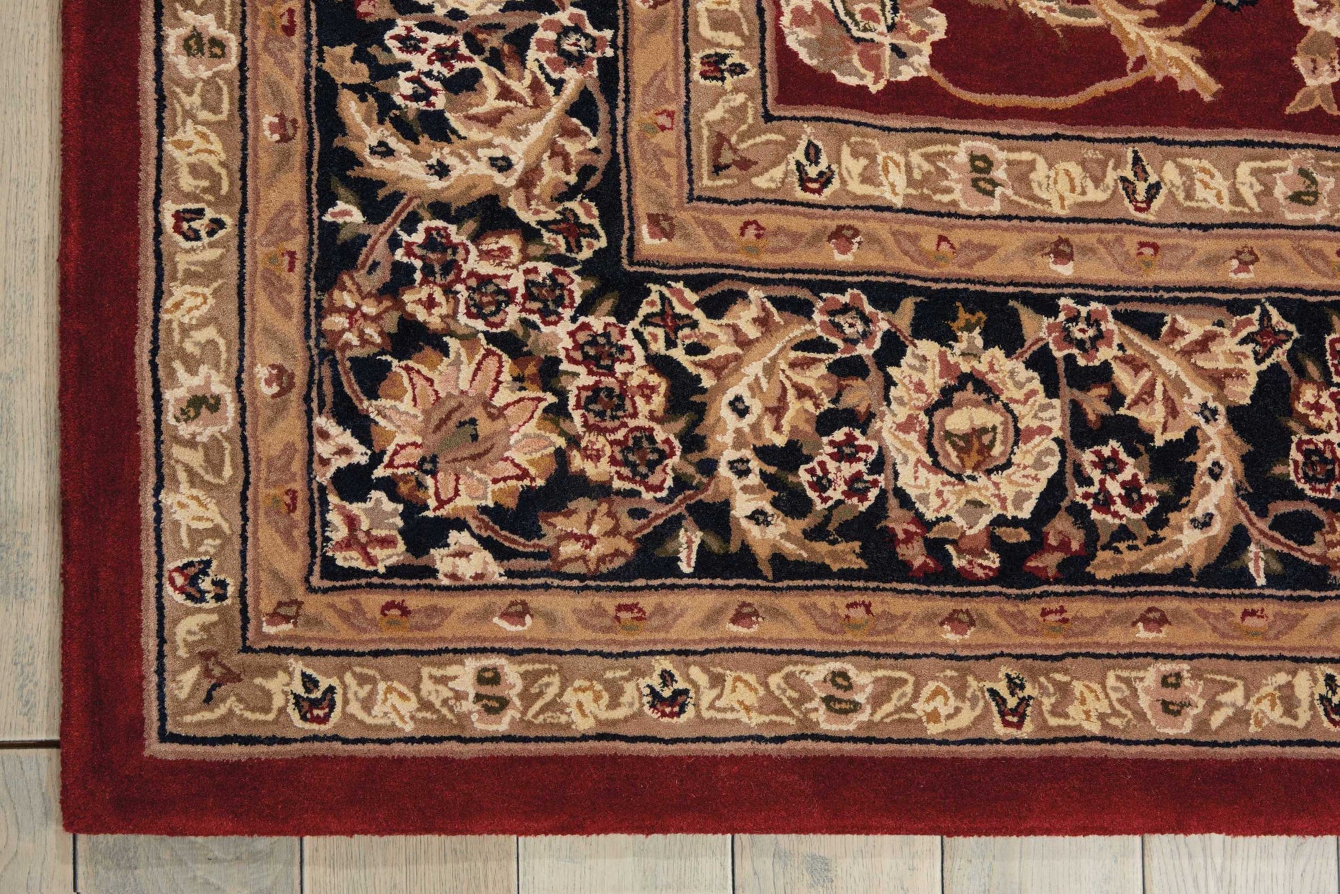 Traditional woven oriental rug with floral medallions, navy field, and beige, gold, and red bordered edges.