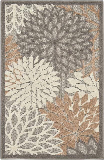 Outdoor rectangular rug, 2' x 3', with oversized cream, charcoal gray, taupe and beige floral rosettes in a textured botanical pattern.