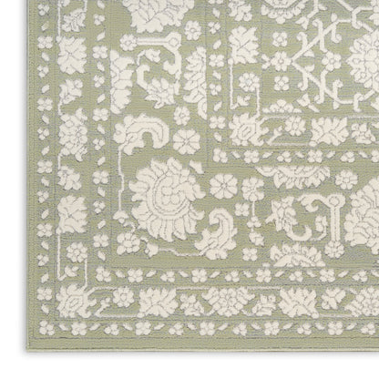 Sage green area rug with white embossed floral damask pattern and decorative border.