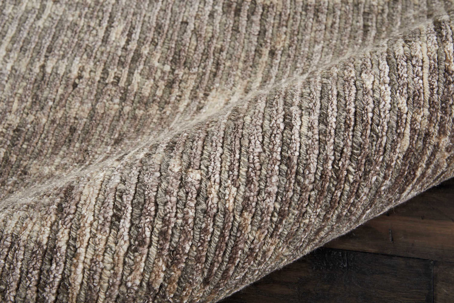 Beige-brown loop-pile textured rug with ribbed stripes, rolled edge on dark wood floor