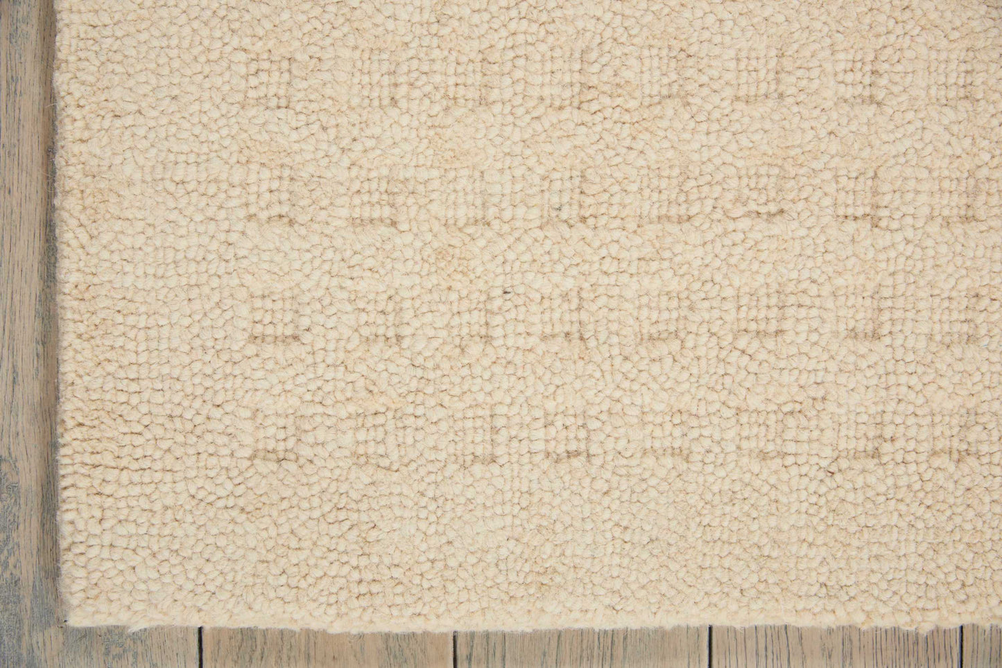 Beige plush shag rug with chunky pile on light wood floor; rectangular, cozy living-room style.