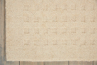 Beige plush shag rug with chunky pile on light wood floor; rectangular, cozy living-room style.
