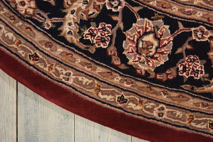Close-up of an ornate Persian-style rug edge with burgundy border and cream floral medallions on a dark field.
